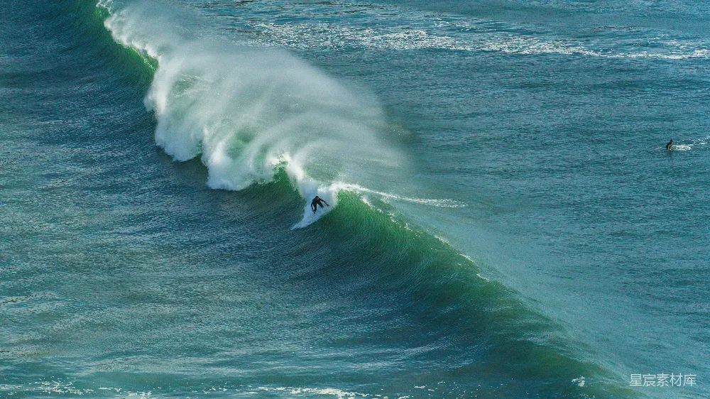 一个骑手在冲浪板上 surfing atop a wave
