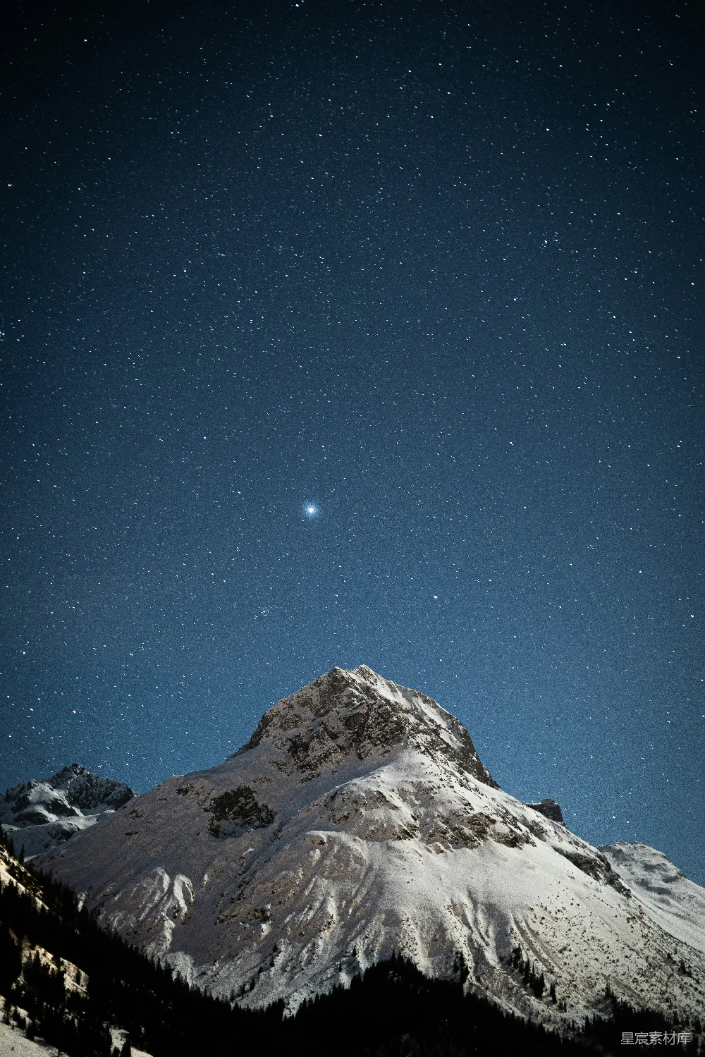 覆盖着白雪的山峦在满天星辰下