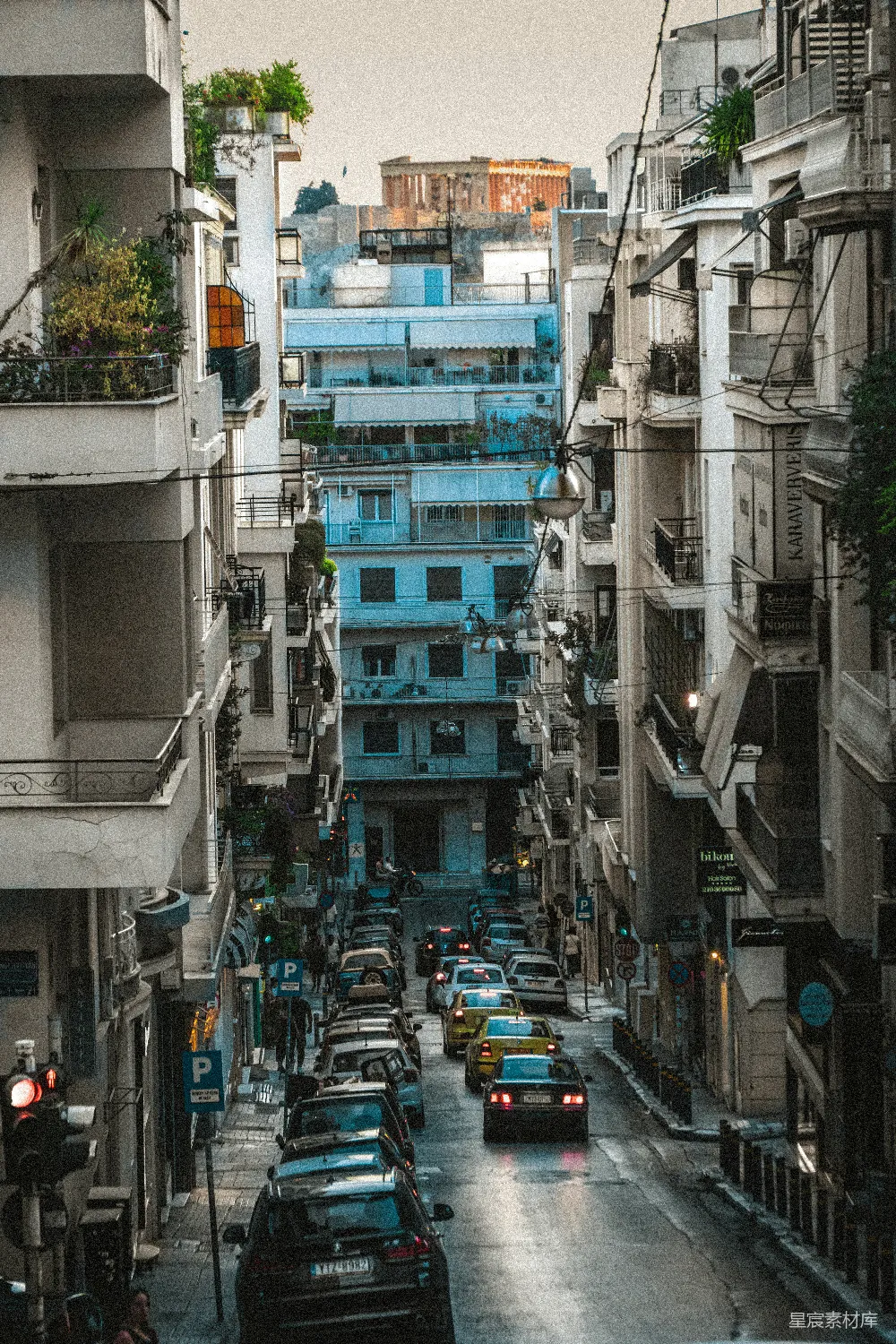 一条街道挤满了车辆，旁边耸立着高大的建筑物。