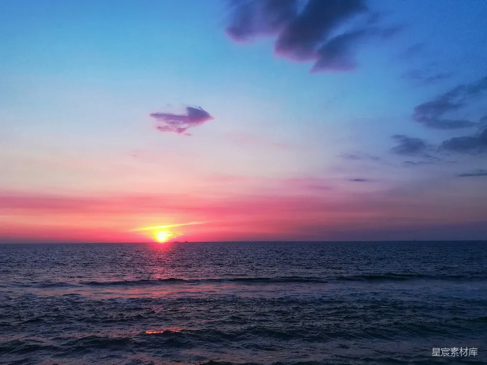 夕阳下的蓝色天空中的大海