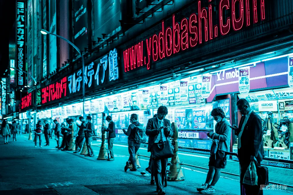 夜幕下人群聚集在亮灯的建筑物旁