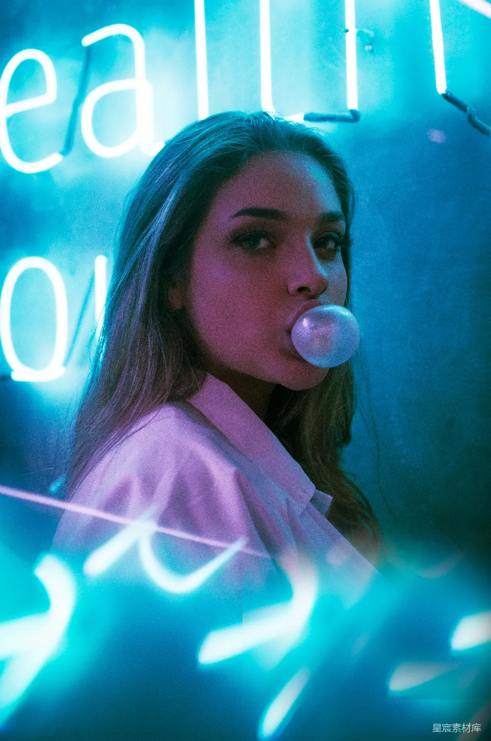 高清摄影 聚焦在吹口香糖的女人的特写照片，她站在一排发光招牌前面