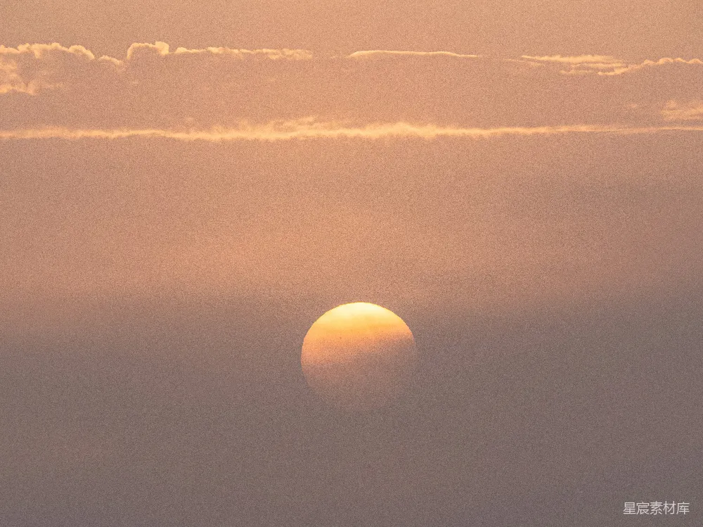 模糊的夕阳穿透轻柔的云层