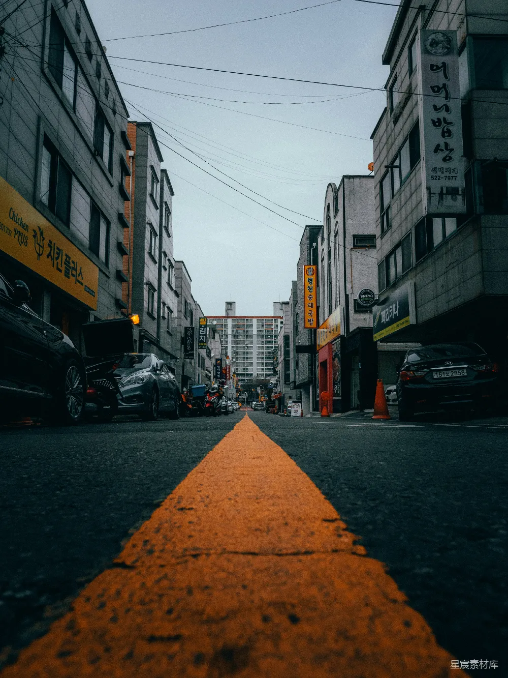 高清摄影  白天，建筑物之间路边停着的汽车。