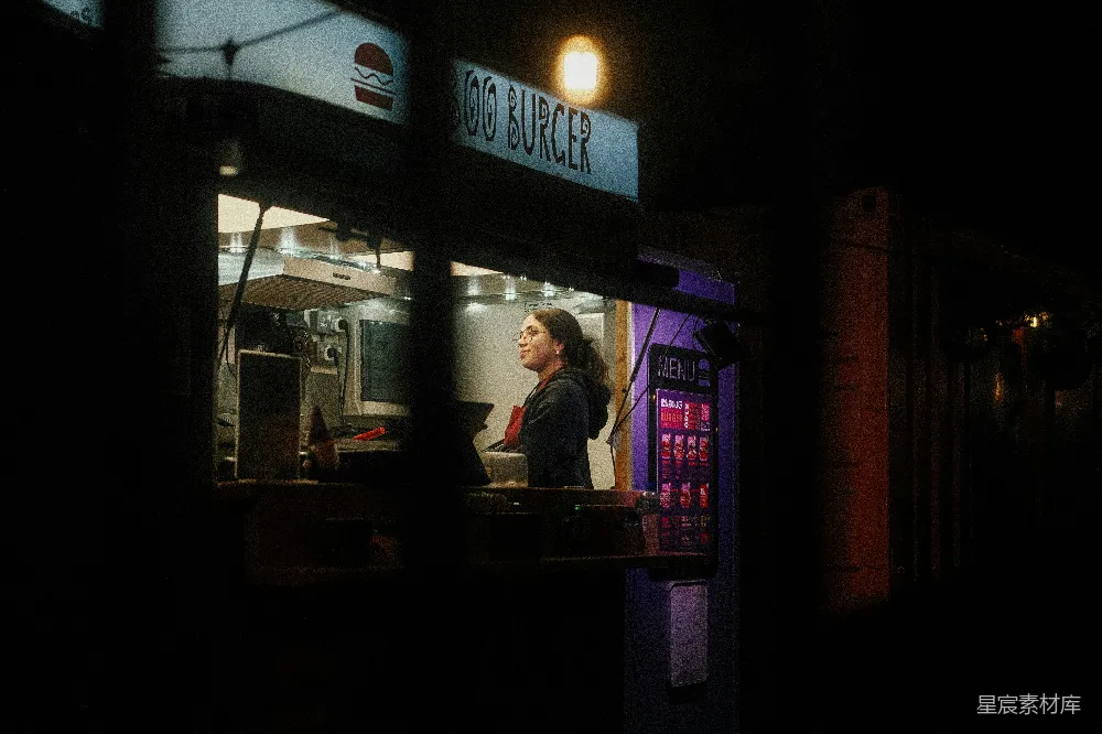 夜晚妇女在一家流动餐馆工作。