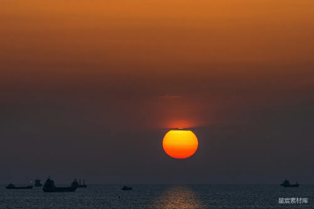 高清摄影  海面上夕阳西下，船在水中漂浮。