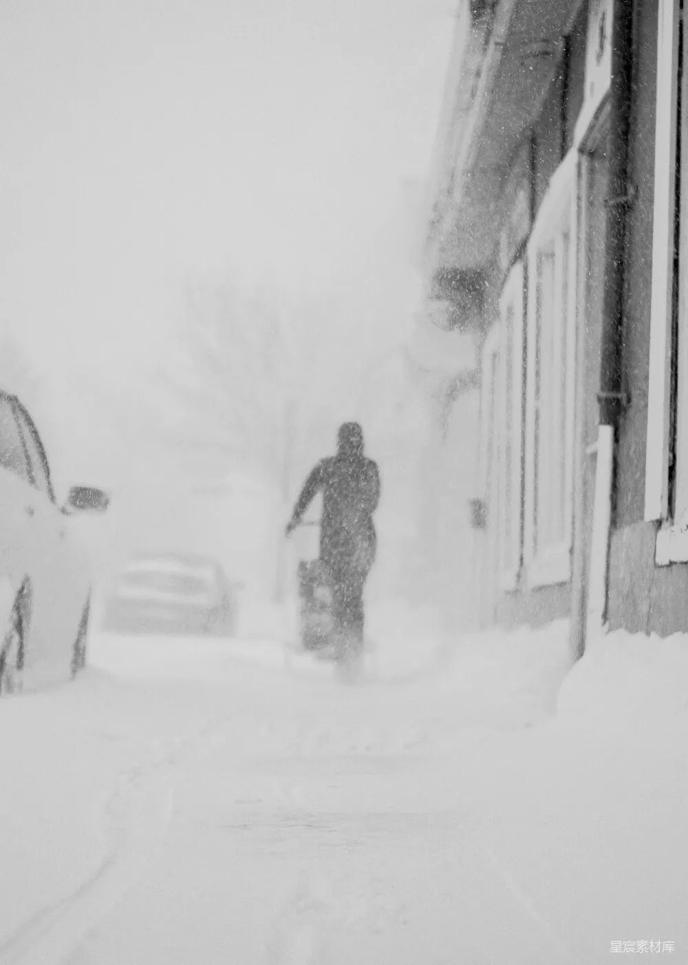 一个男子走在覆盖着积雪的街道上