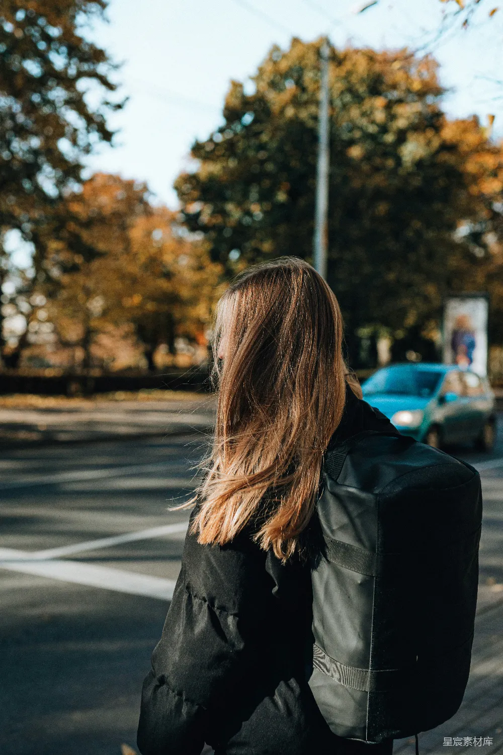 一位妇女正在街道上滑板车骑行。