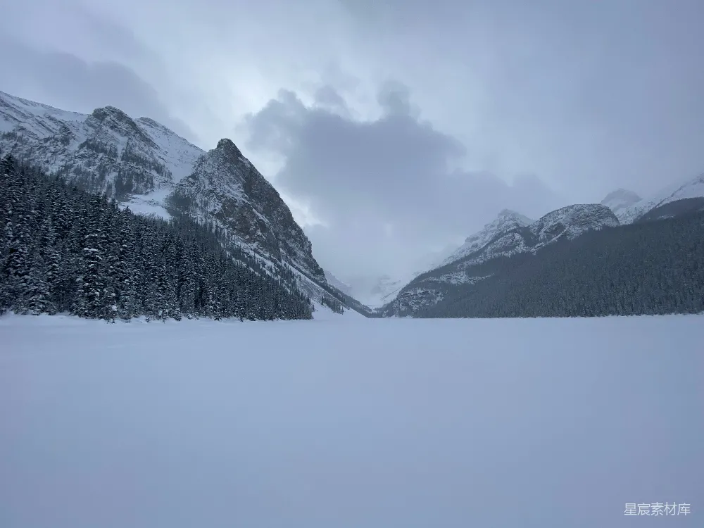 白天云层覆盖下的山被白雪覆盖