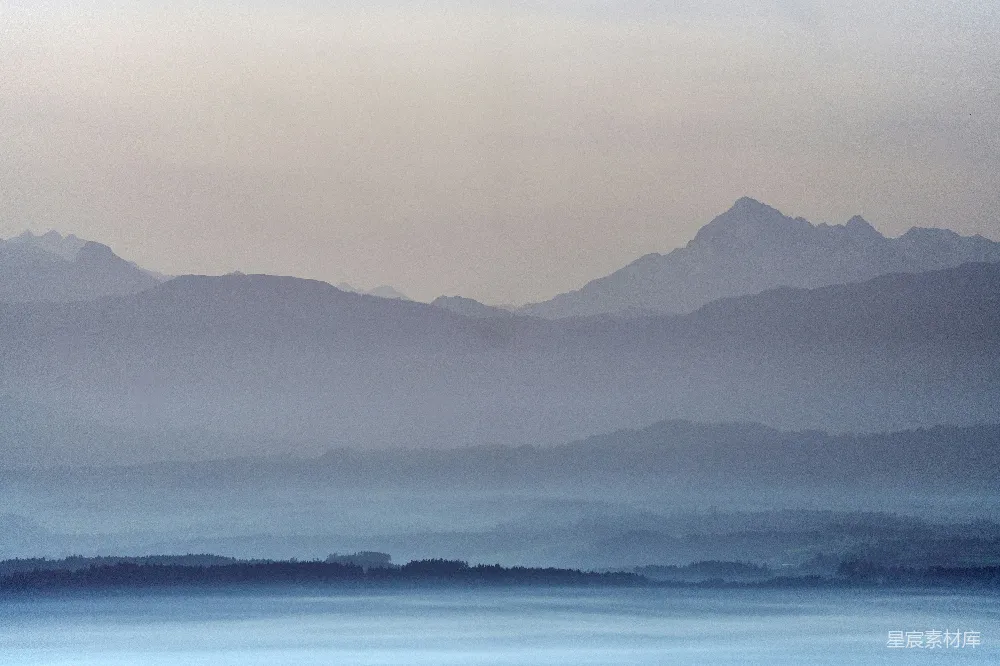 迷蒙的山峦升起于一片雾气的天空。