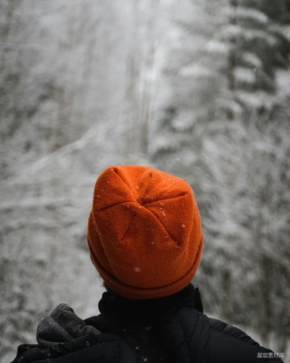 高清摄影  一个戴着橙色帽子的人在雪地里。
