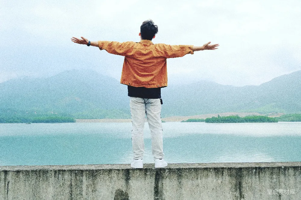 站在墙上的男子双臂张开