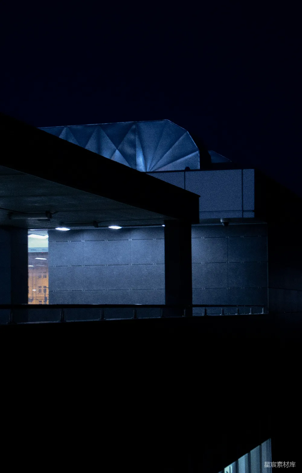 夜晚灯火辉煌的建筑，背景是钟楼。