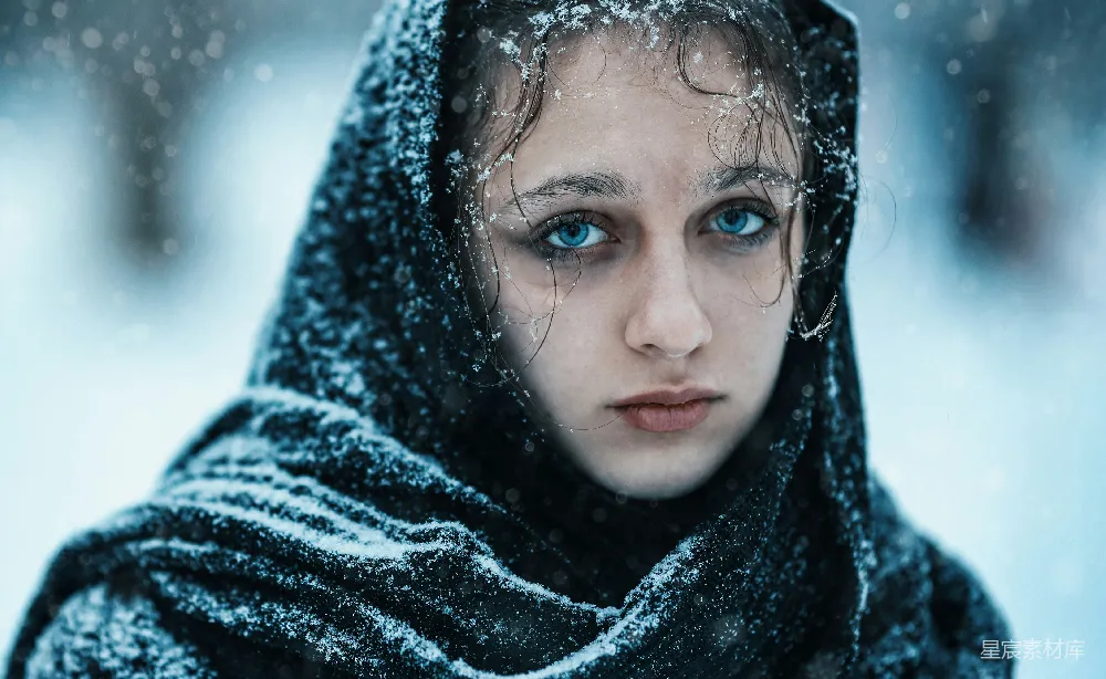 高清摄影  一个蓝眼睛的女人被雪覆盖着。