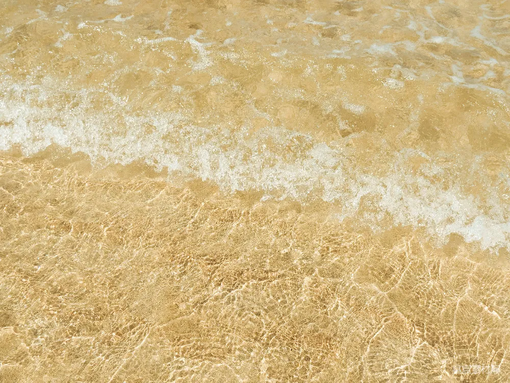 清澈的海水泛着小白浪，金色的沙滩上。