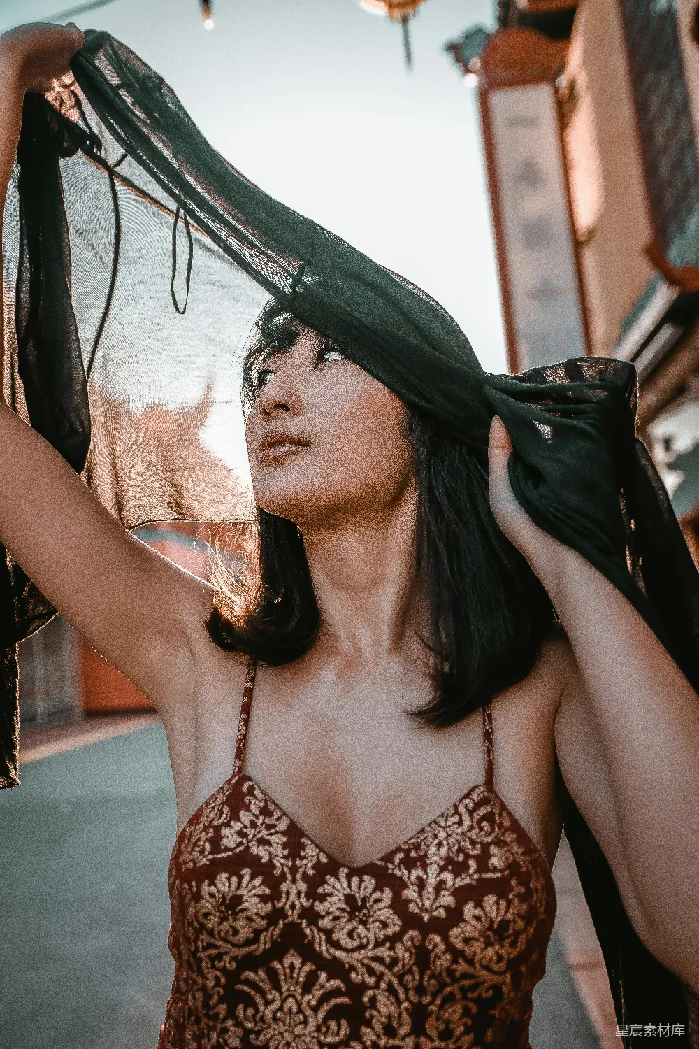 黑白花卉款式白背心的女士正在手持黑色布料。