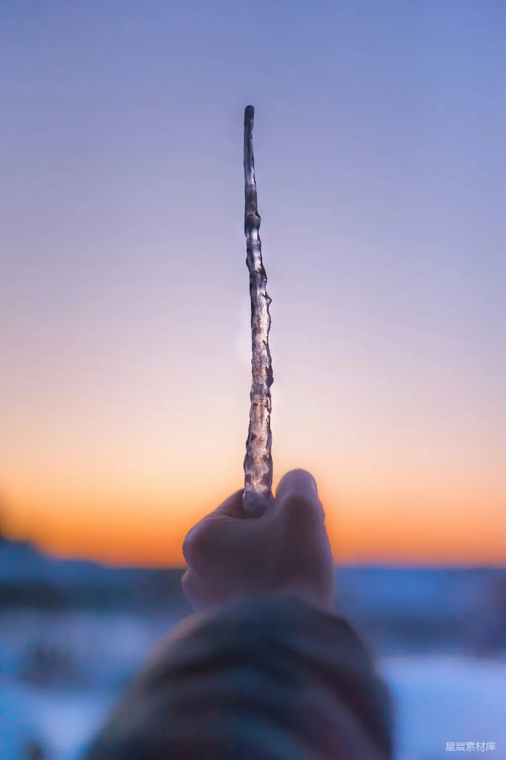 高清摄影  在夕阳下，一个人手里拿着一条银色的项链。