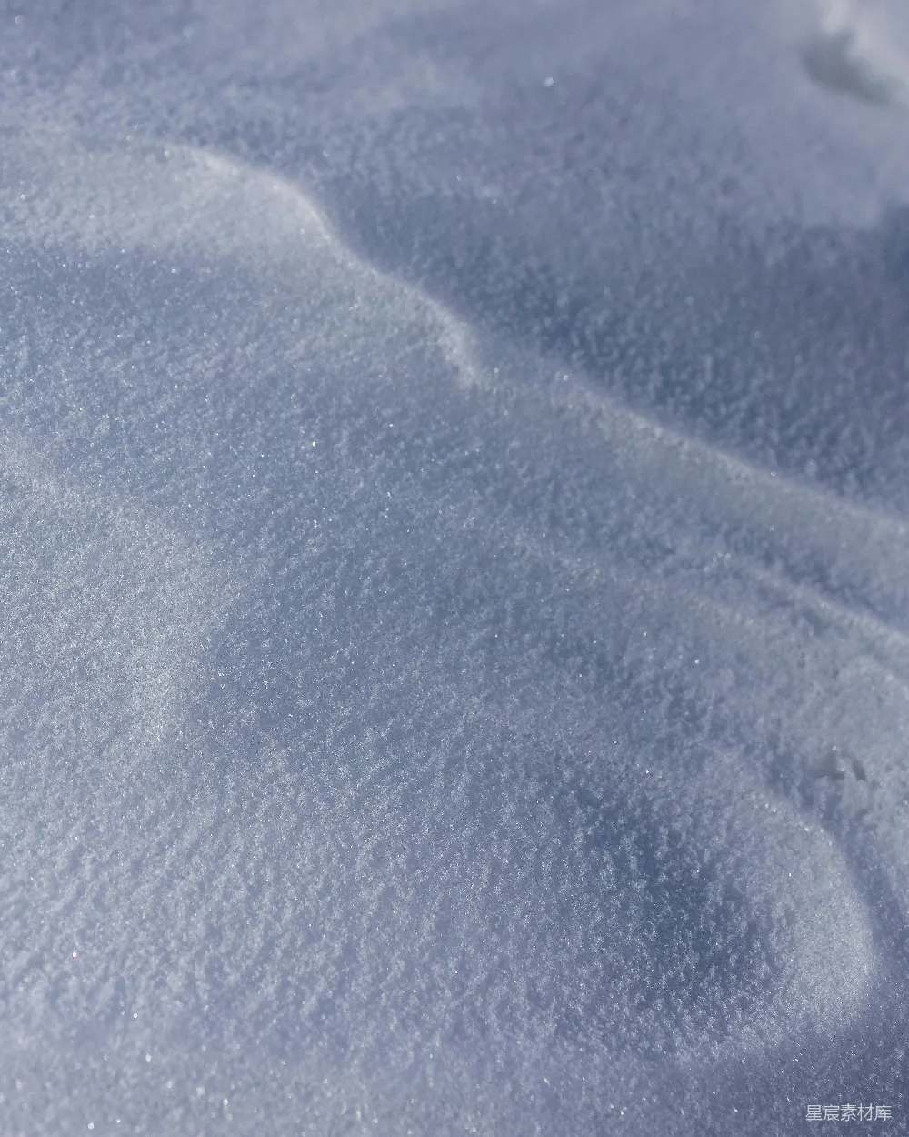 高清摄影  一片被雪覆盖的地面，上面放着一块滑雪板。