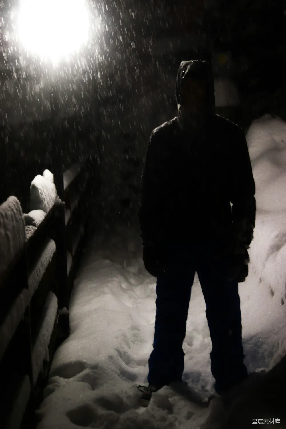 高清摄影  一个站在雪地里的人在夜晚。