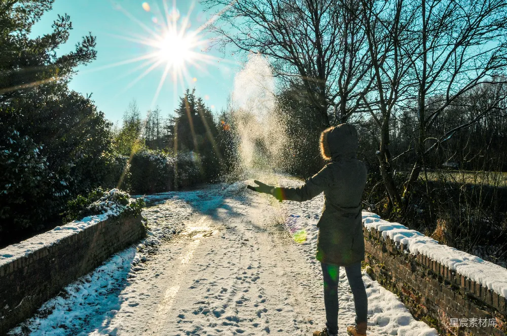 高清摄影  穿绿色夹克的人在白天走在覆盖着积雪的地面上。