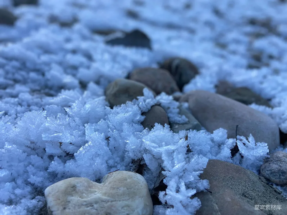 高清摄影  一颗心形的石头坐在覆盖着雪的岩石上。