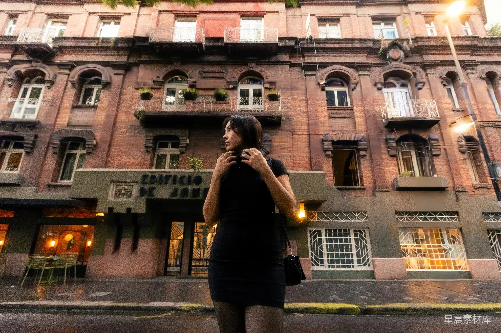 黑衣女子站在一座旧建筑前