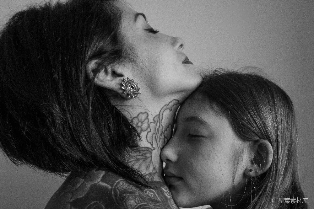 颈部有纹身的女人正抱着一个年轻女孩。