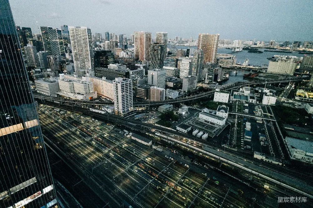 现代城市风光，黄昏时分有亮灯的铁轨。