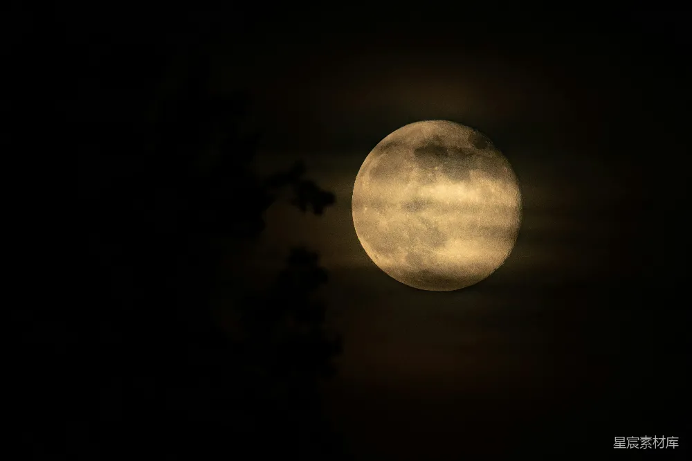 满月被夜空中云层部分遮挡。