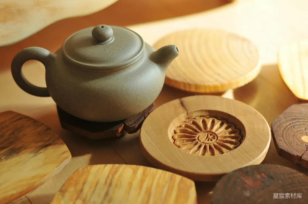 高清摄影  白色的陶瓷茶壶放在棕色的圆形木桌上。