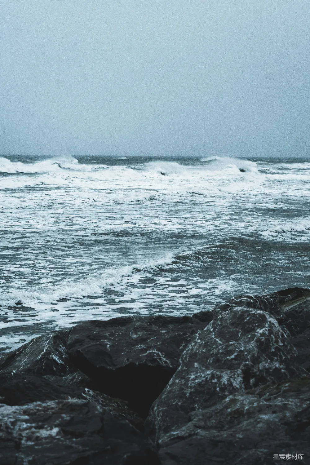 白天海浪撞击岩石的景象