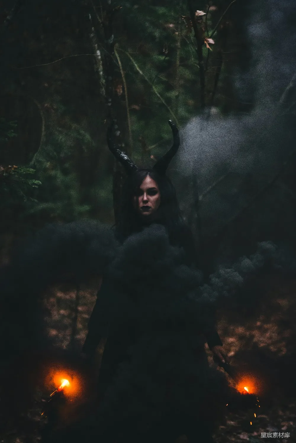 一个长着角的女人站在森林中