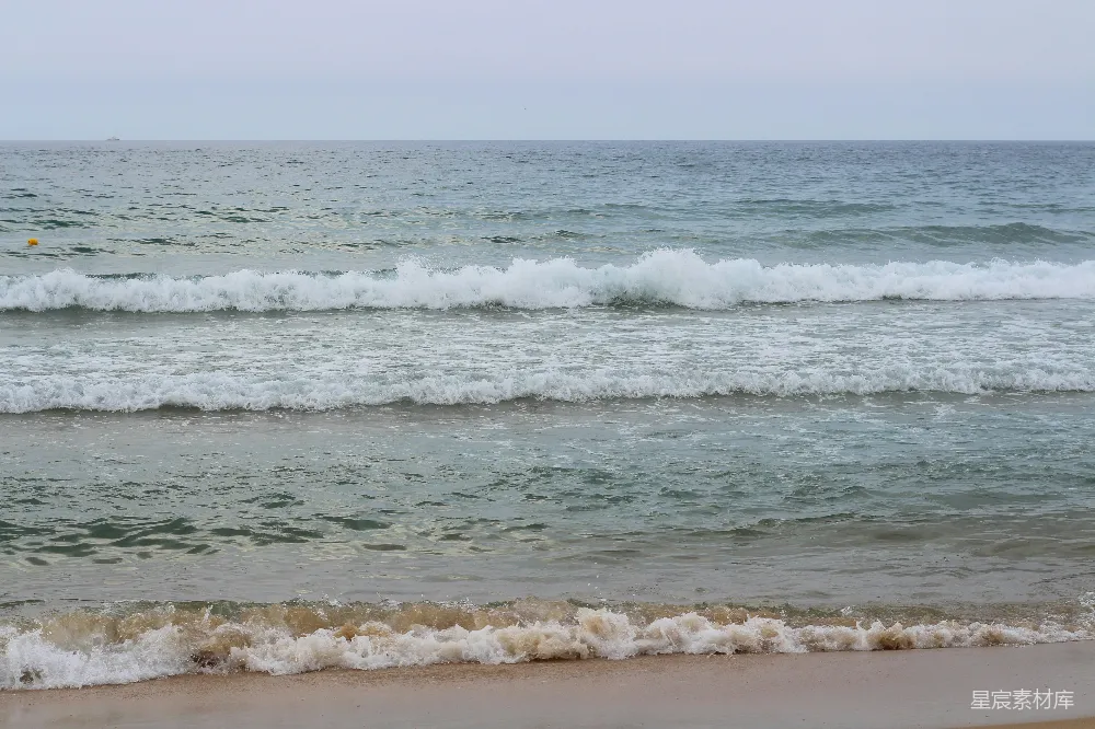 海滩上一个人拿着冲浪板行走