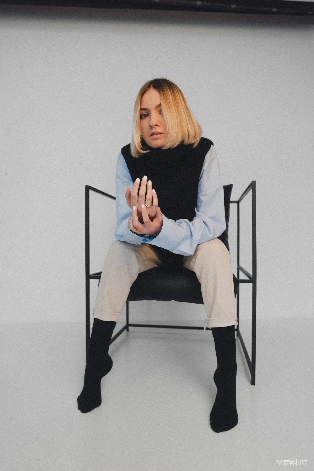 一个女人坐在椅子上双手合十