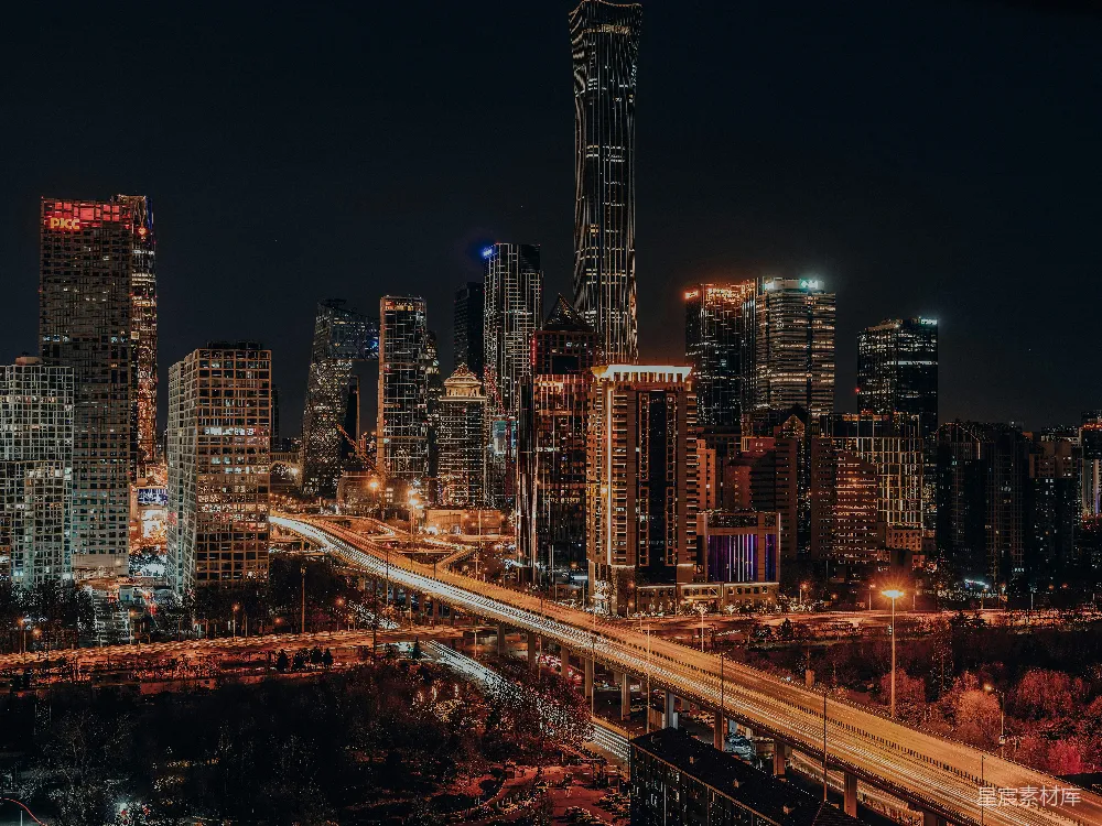 城市夜景中的高楼大厦间有条高速公路贯穿其中