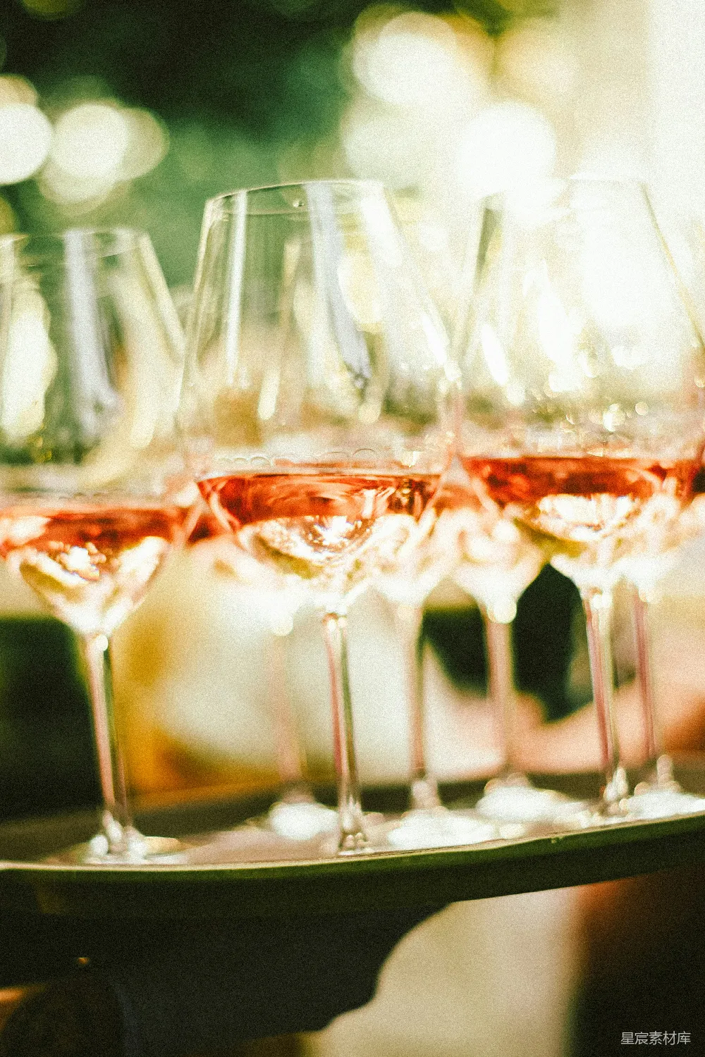 酒杯中的玫瑰红酒放在托盘上。