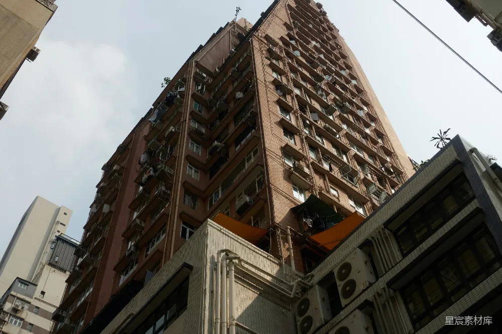 高耸的公寓建筑有许多窗户和空调装置。