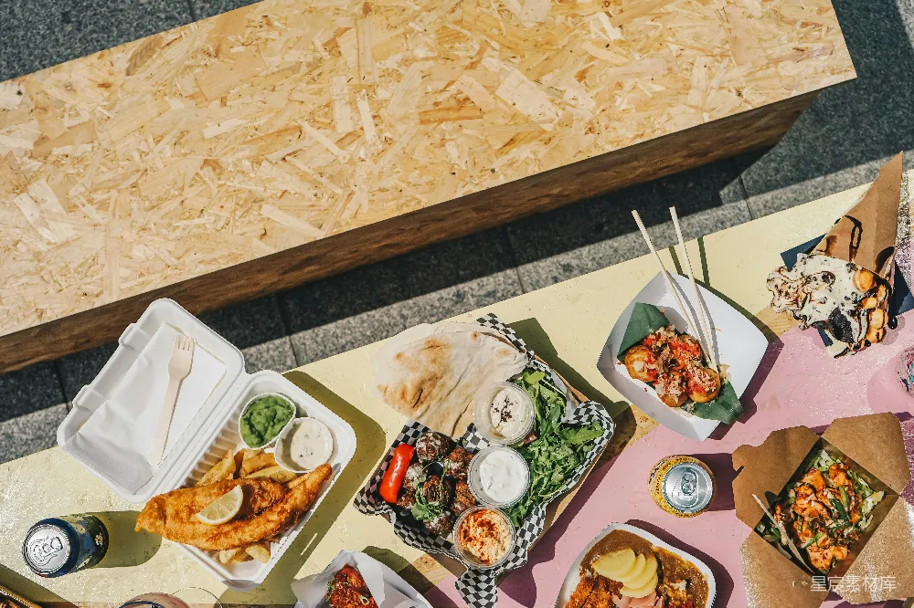 一张桌上摆满了食物旁边是一张木制的长凳。