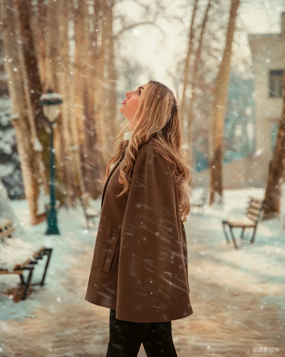 一个穿着棕色外套的女人在雪地中行走。