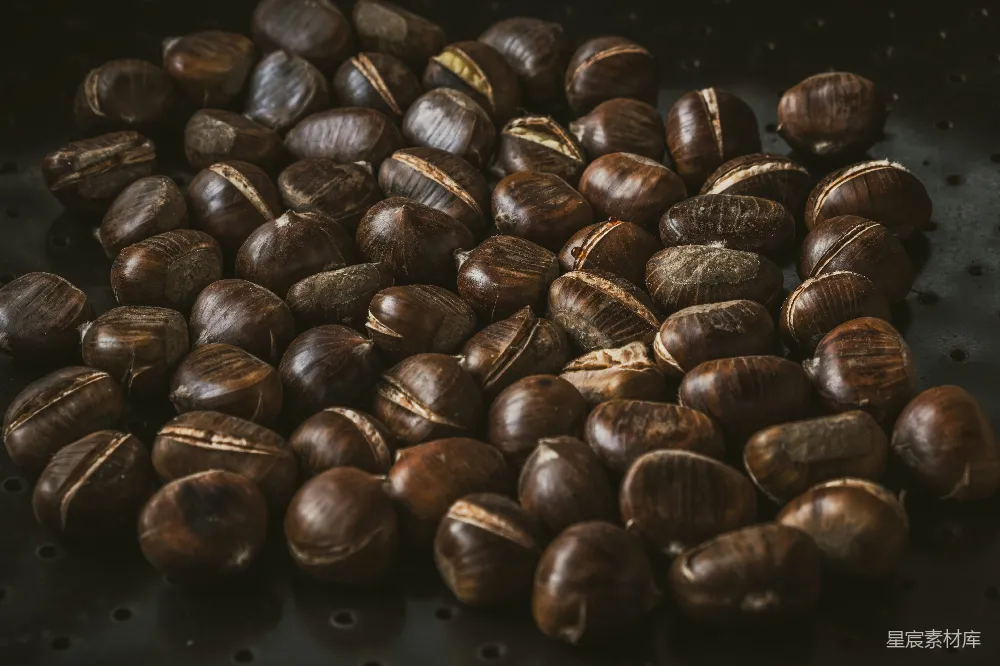 一堆带裂纹壳的烤栗子。