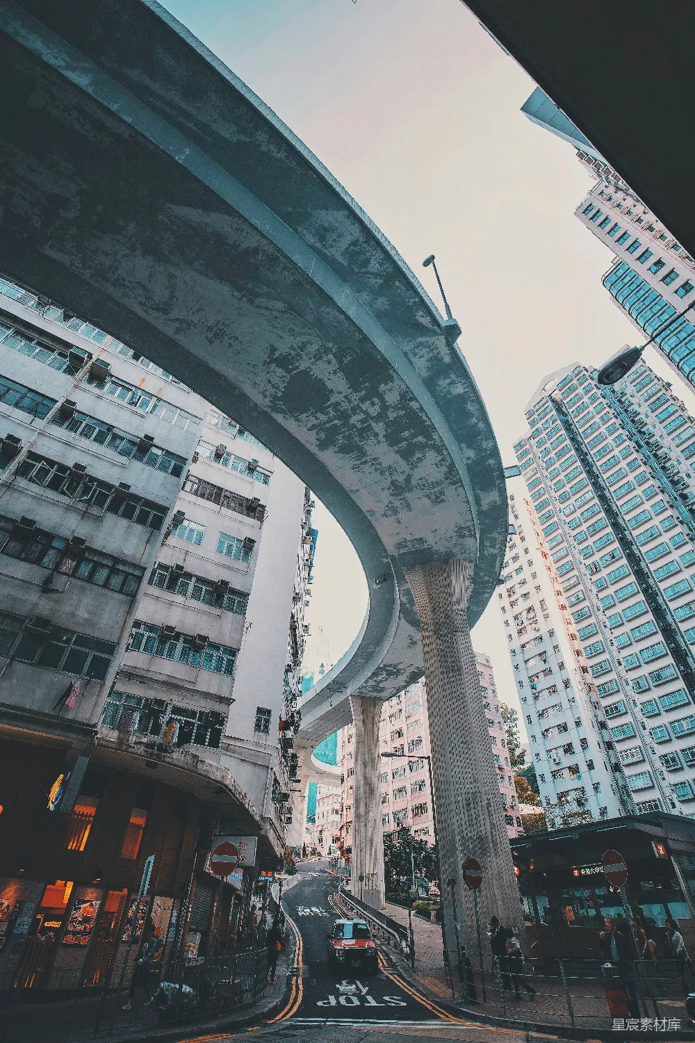 路上的汽车靠近高-rise建筑在白天