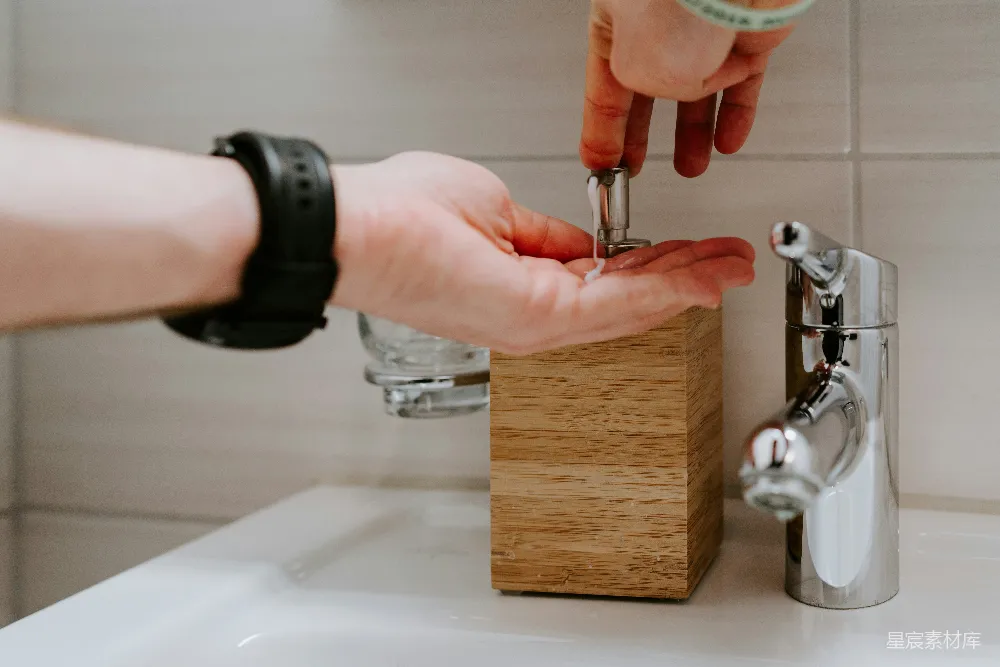 手持银色水龙头的人在 sinks 上