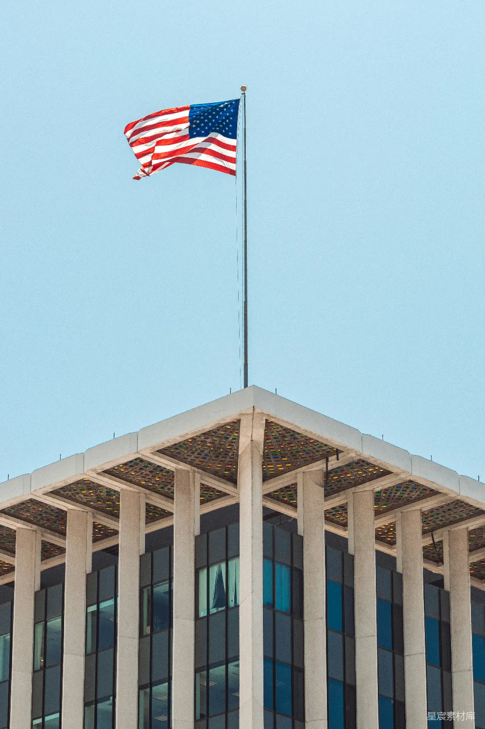 现代建筑顶部飘扬着美国国旗