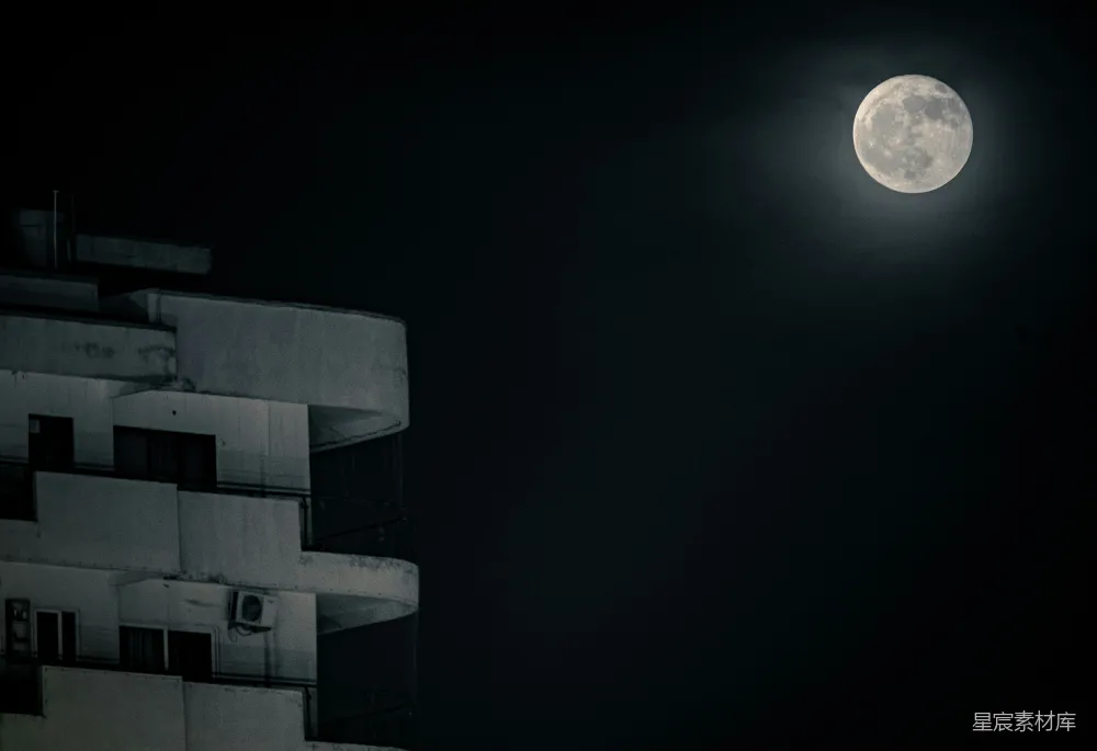 一座建筑矗立在夜空中的满月旁。