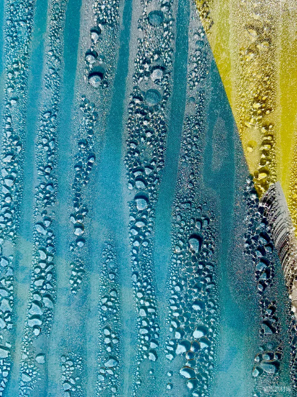 高清摄影  一幅蓝色和黄色相间的画，上面有水滴。