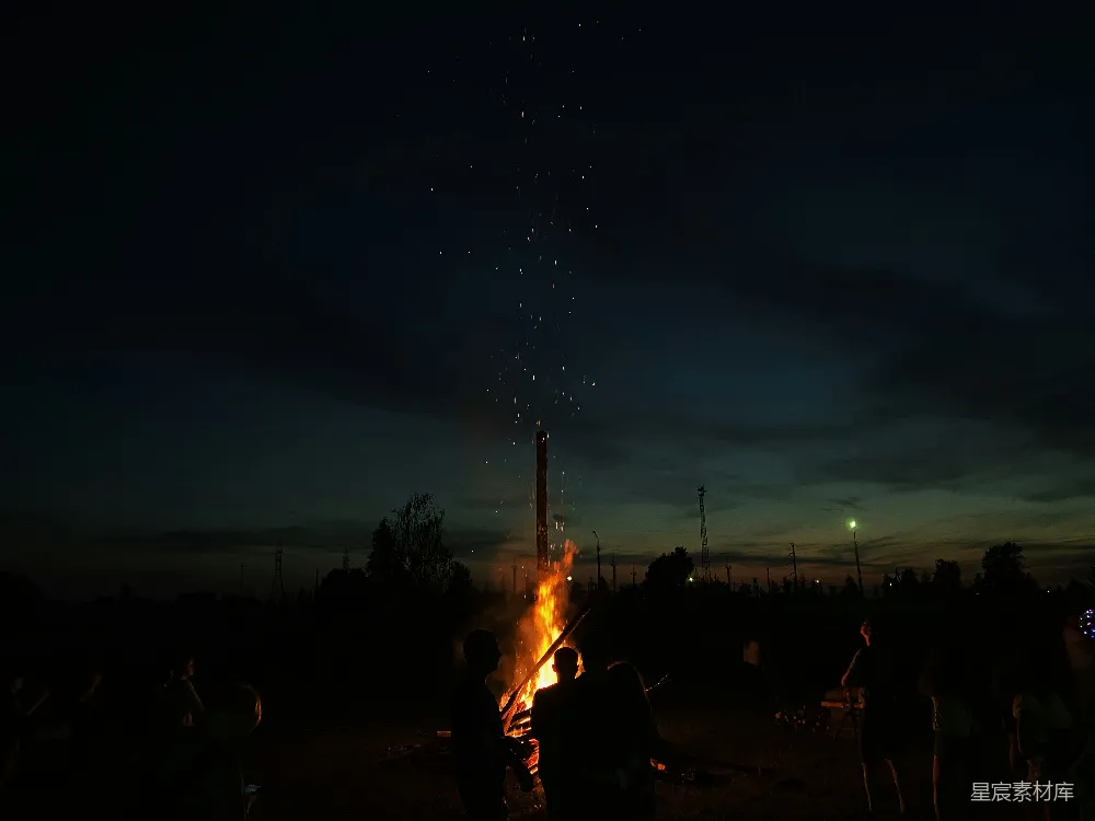 夜晚人们站在篝火旁。