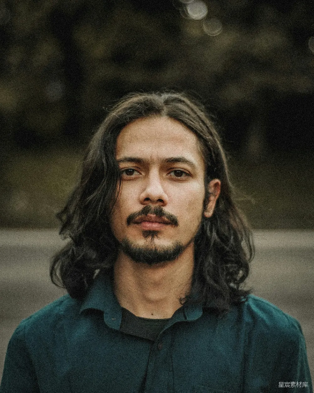 一个留长发的男人穿着绿色的衬衫