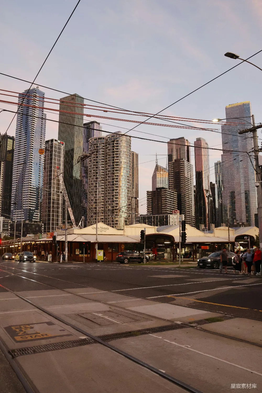 傍晚的城市 skyline，高楼林立， tram 轨道隐约可见。