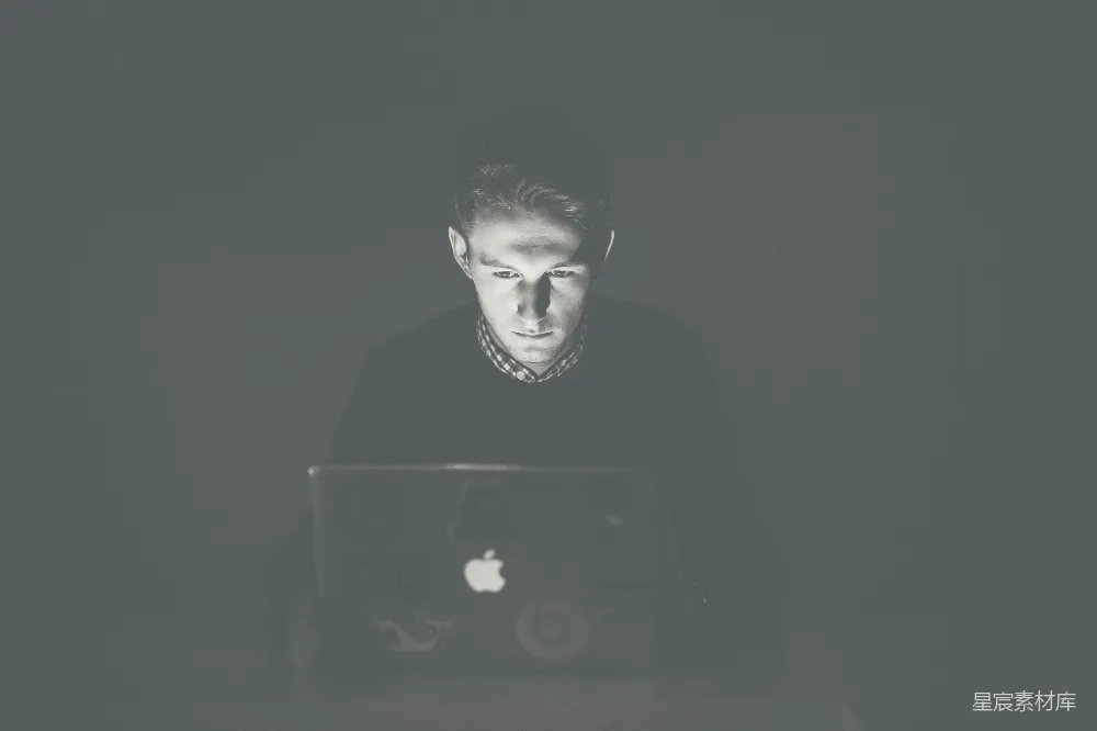 男人盯着黑色的MacBook