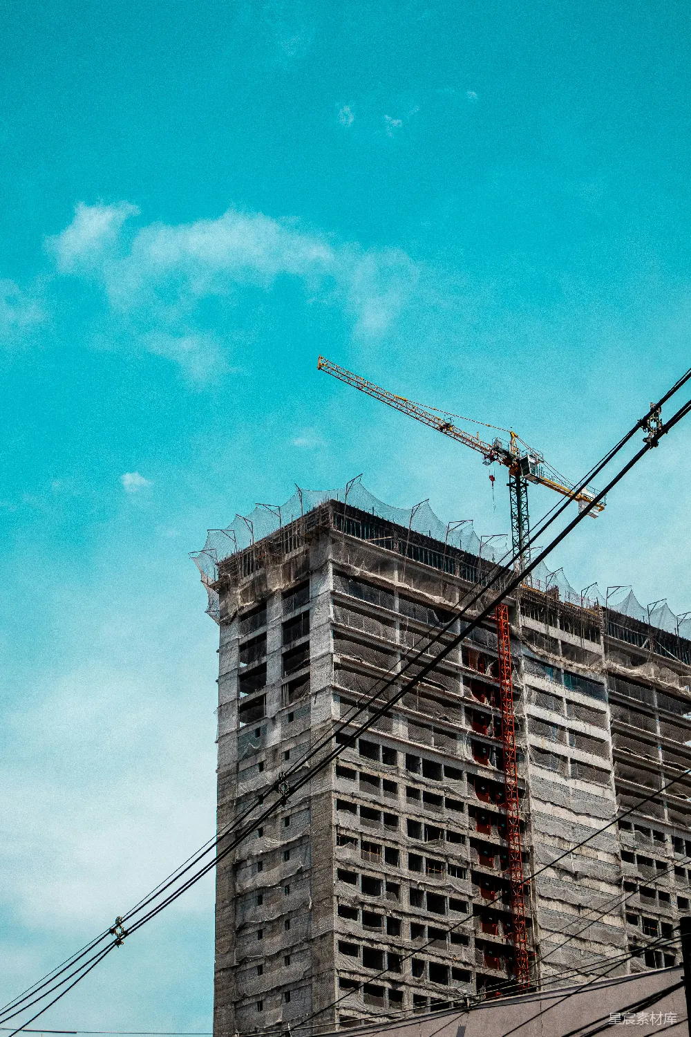 高清摄影  在蓝天下的未完工建筑上的起重机